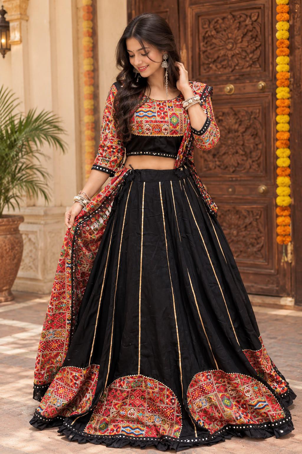 Woman in a black lehenga with gold stripes and red arched embroidery at the hem